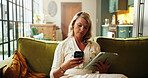 Phone, tablet and typing with woman on sofa in living room of home to search for holiday review. App, reading and text message with person in apartment for online booking of vacation accommodation