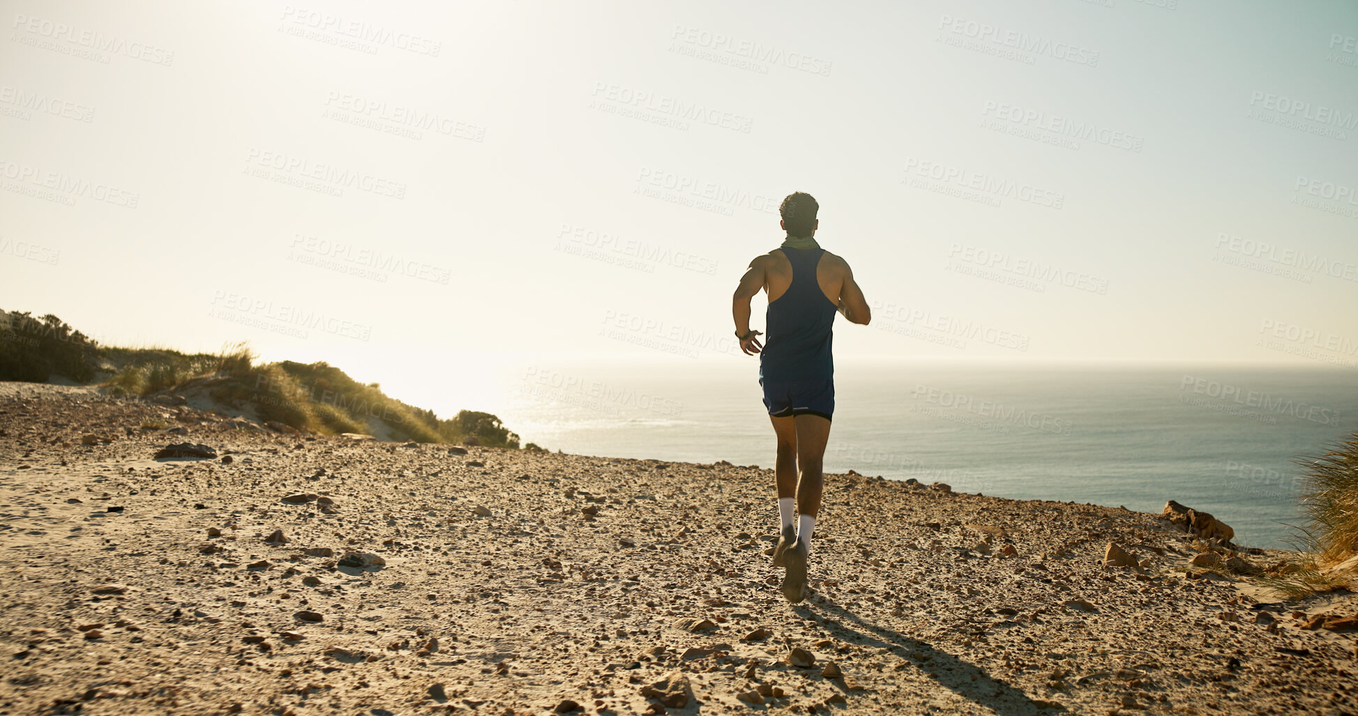 Buy stock photo Back, horizon and running at ocean with man on sand outdoor for adventure or fitness hobby. Coast, exercise or sea view and person training on cliff in nature for cardio or wellness with mockup space