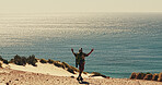 Celebration, hiking and horizon at ocean with man on sand outdoor for fitness or hobby from back. Exercise, milestone and sea view with hiker in nature for physical activity, trekking or wellness