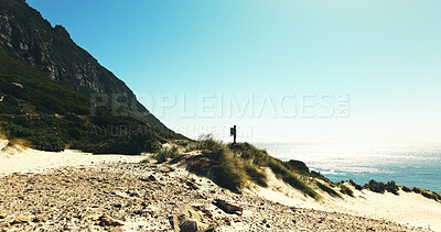 Buy stock photo Horizon, hiking and man with view for travel, adventure or fitness for journey with backpack. Male person, trekking and explore dune for exercise, eco tourism and nature space for holiday or vacation