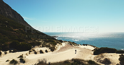 Buy stock photo Above, hiking and horizon at ocean with man on sand outdoor for adventure, fitness or hobby. Exercise, mountains and sea view with hiker walking in nature for physical activity, trekking or wellness