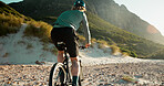 Cycling, mountain and back of man on bicycle with fitness, workout or training for wellness. Outdoor, cyclist and male athlete on bike with cardio exercise for health, triathlon or sports in nature.