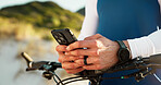 Hands, cycling and man with phone in nature for networking, chatting or connectivity with training. Fitness, cyclist and athlete with cellphone for texting, communication or contact on mobile app.
