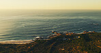 Ocean, rocks and above with waves, landscape and sky with nature, environment and beach by hill. Sea, horizon and drone view for marine ecosystem, conservation or sustainability with space in summer
