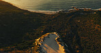 Ocean, rocks and above at beach, landscape and dunes with nature, environment and plants on hill. Sea, waves and drone view for marine ecosystem, conservation or sustainability with sand in summer