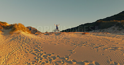 Buy stock photo Dune, bicycle and man with celebration for sunset view, travel and fitness for journey with banner. Person, cycling and explore for exercise, eco tourism and nature space for holiday or vacation