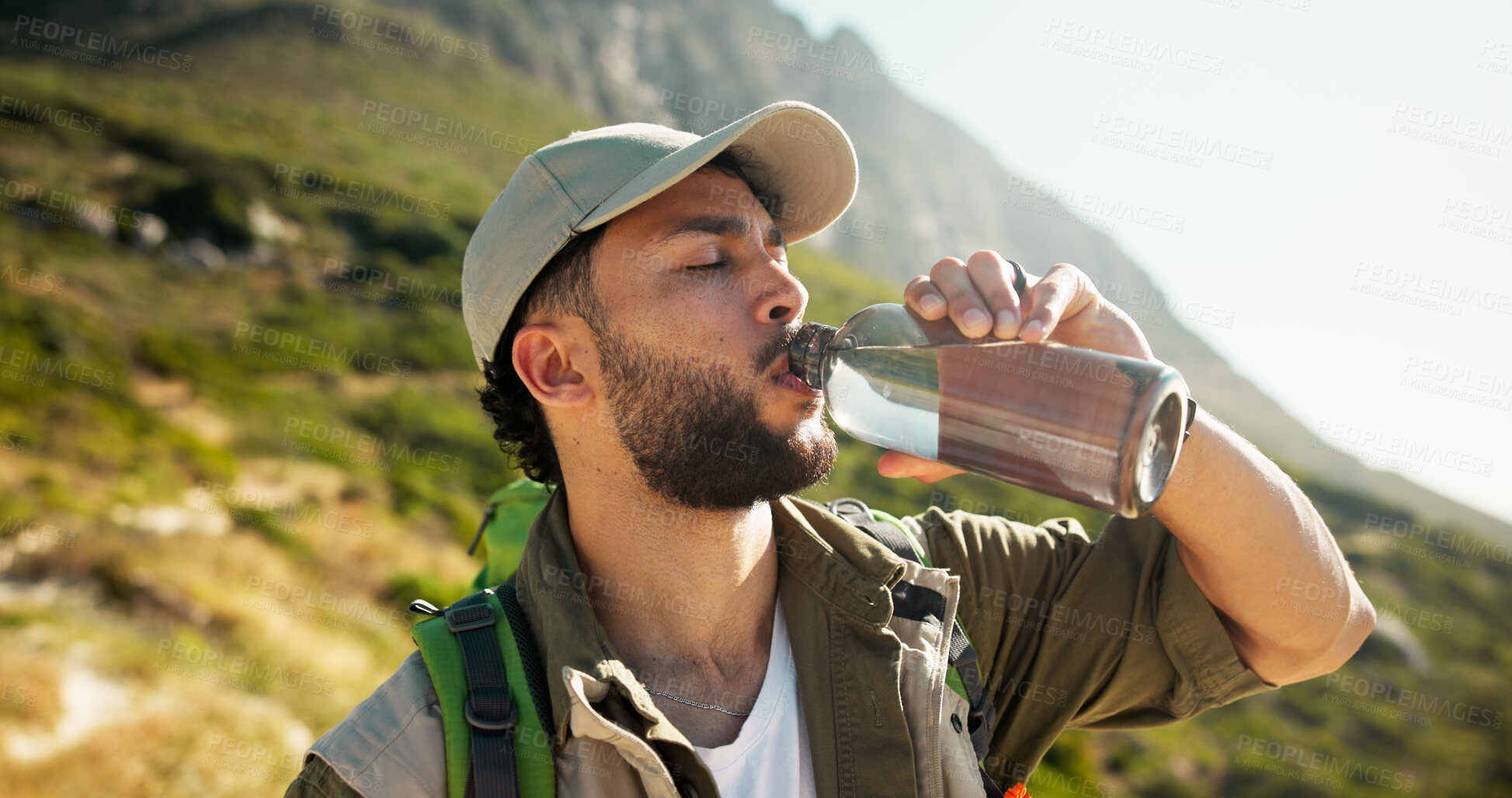 Buy stock photo Mountain, relax and man drinking water for hiking hydration, summer traveling or eco tourism on nature trip. Outdoor, wellness and person with liquid bottle for break, trekking or thirsty on vacation