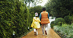 Back, outdoor or father with daughter on path for holiday, connection or holding hands for support. Care, travel trip or man walking with child for bonding, family vacation or explore park together