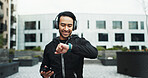 Fitness, headphones and watch with man in city for cardio training, running or workout tracking. App, exercise and time with athlete or runner streaming music for outdoor challenge or sports
