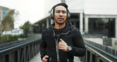 Buy stock photo Fitness, music and running with man on bridge in city for cardio, training or workout routine. Exercise, headphones and streaming with athlete or runner outdoor challenge, performance or sports