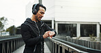 Headphones, athlete and check watch with running in city for workout progress, performance monitor or app. Runner, man and technology for training, fitness and exercise for podcast or music streaming