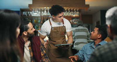 Buy stock photo Waiter man, tablet and friends at bar for order, talk and option for drinks, choice and wine list. People, group and server with tech, digital menu app or customer experience with decision at pub