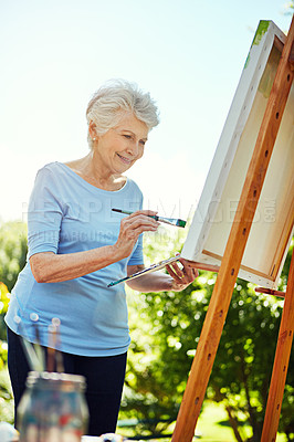 Buy stock photo Smile, senior woman and painting outdoor on canvas, nature inspiration and creative art. Elderly person, brush and drawing sketch on easel for artwork, craft technique and diy creation for retirement