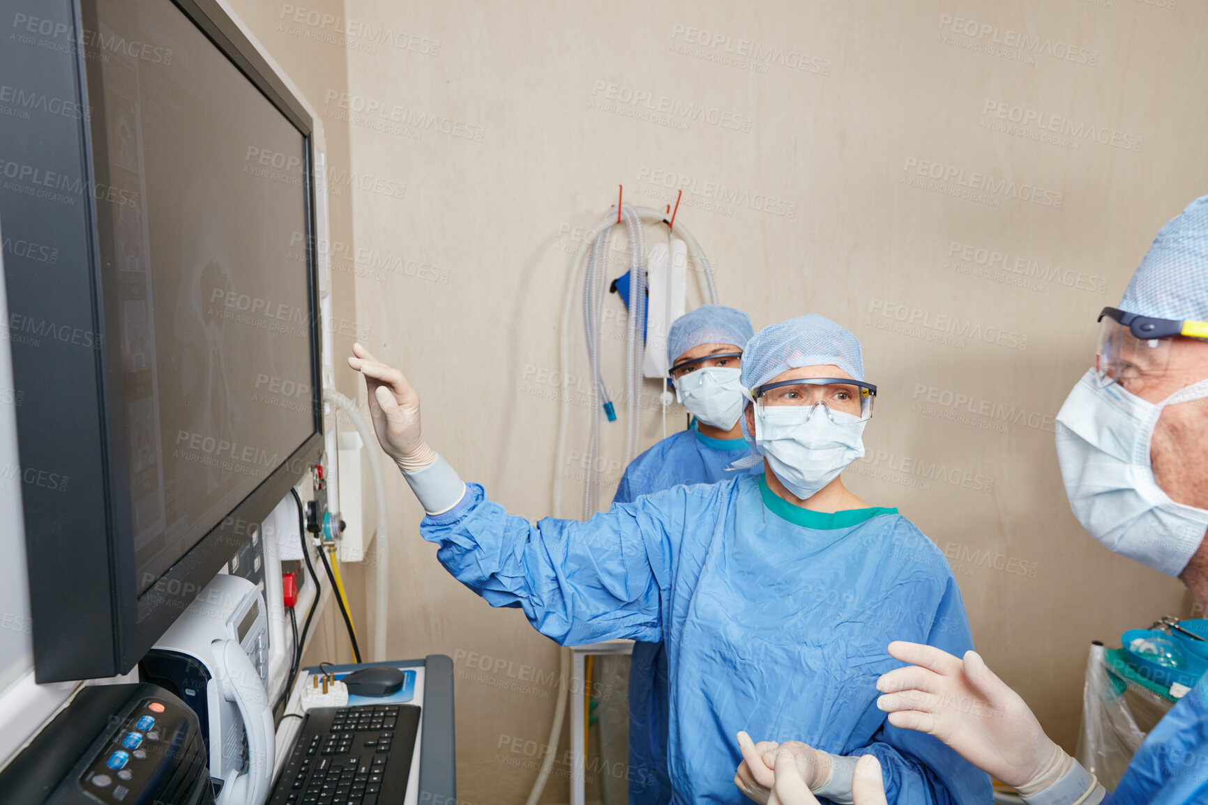 Buy stock photo Surgeon, people and planning at monitor with meeting, talk and emergency room with insight at hospital. Doctors, medical staff and team with scan for feedback, point or face mask in theater at clinic