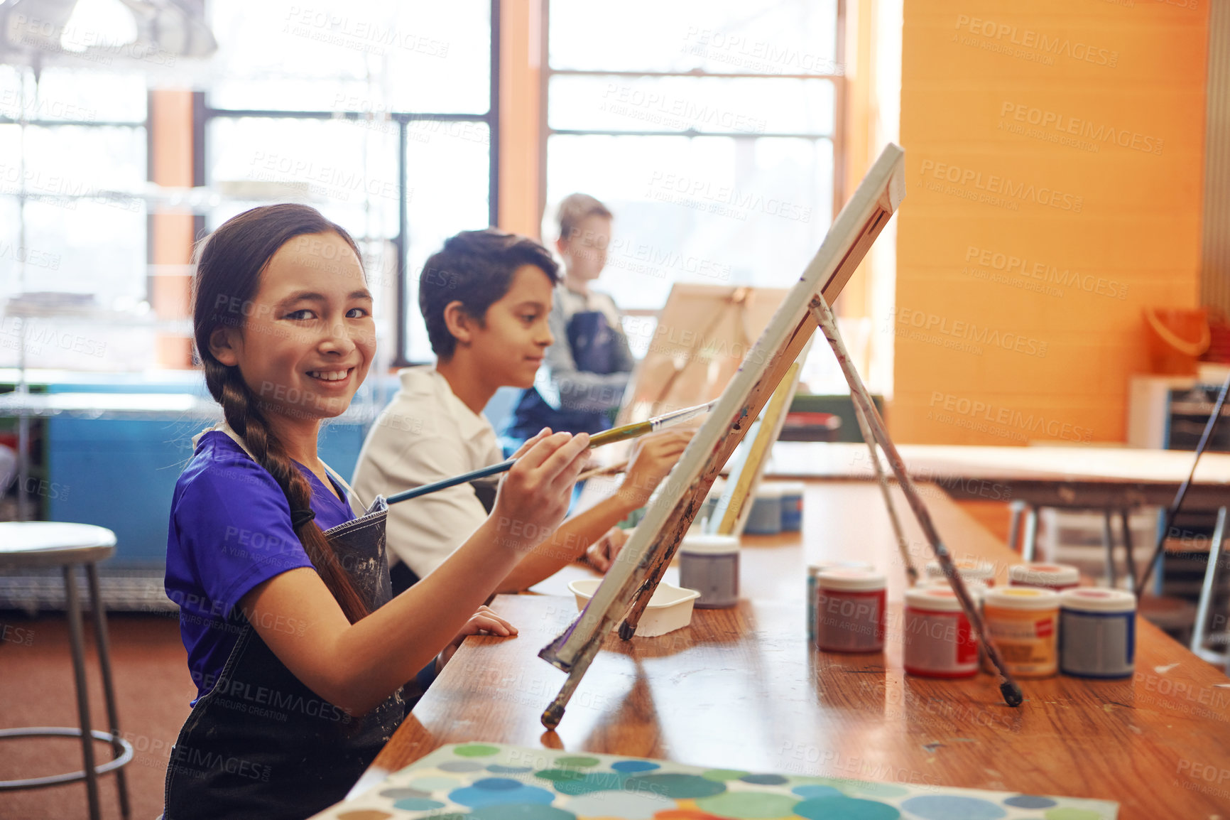 Buy stock photo Portrait, painting or girl with smile for class, creative creation or fine motor skill development in art. Education, artistic learning or happy students with canvas for lesson, paint brush and child