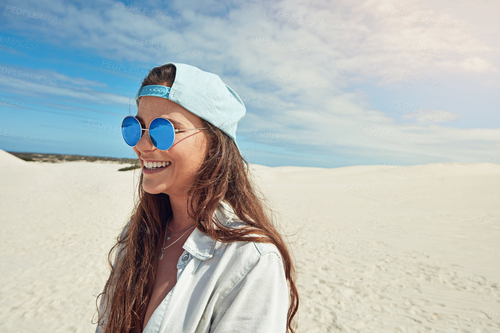 Buy stock photo Smile, space and sunglasses with woman outdoor on sand dunes for adventure, holiday or vacation. Blue sky, shades and travel with happy person in nature for break, summer getaway or weekend trip