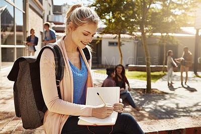 Buy stock photo University student, girl and writing in notebook on campus for course notes, study tips or journaling. Happy, person and notepad outdoor at college for test preparation, essay planning and learning