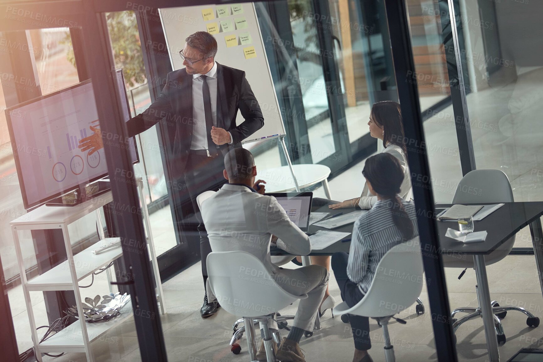 Buy stock photo Businessman, presentation and review at office meeting with graphs, screen and team for finance report. Speaker, group and feedback with monitor, glass and charts for revenue at investment agency