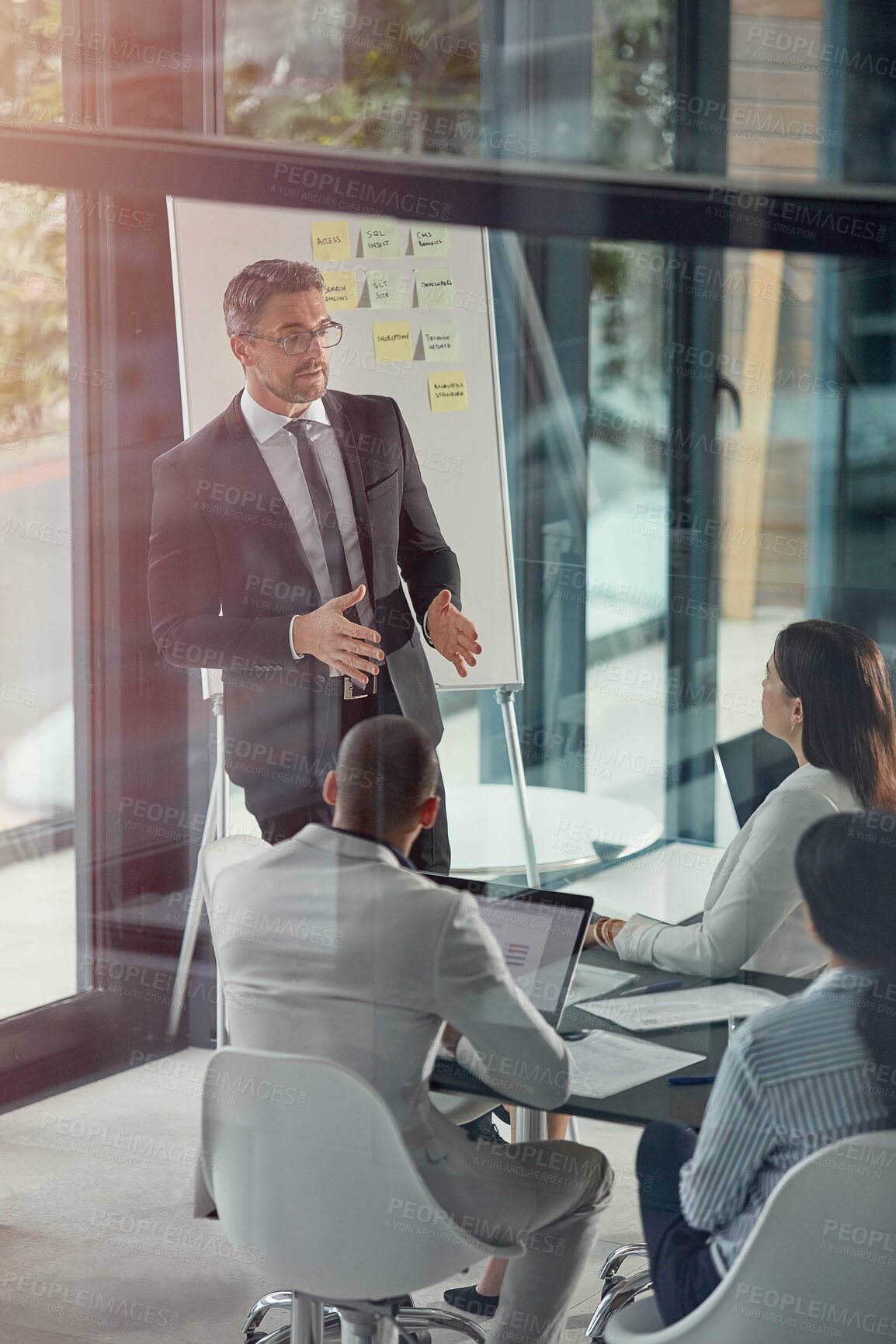 Buy stock photo Businessman, presentation and review in boardroom with team, discussion or insight at finance company. Speaker, group and feedback at office meeting, glass or talk for planning at investment agency