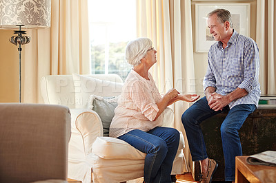 Buy stock photo Senior couple, relax and talking at house with love, gossip discussion and bonding together. Elderly people, explain and conversation with partner, friendly chat and listening to story in living room