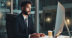 Computer, night and serious with business man at desk in office for administration or research. Information, reading and report with confident employee typing on PC for deadline or overtime at work