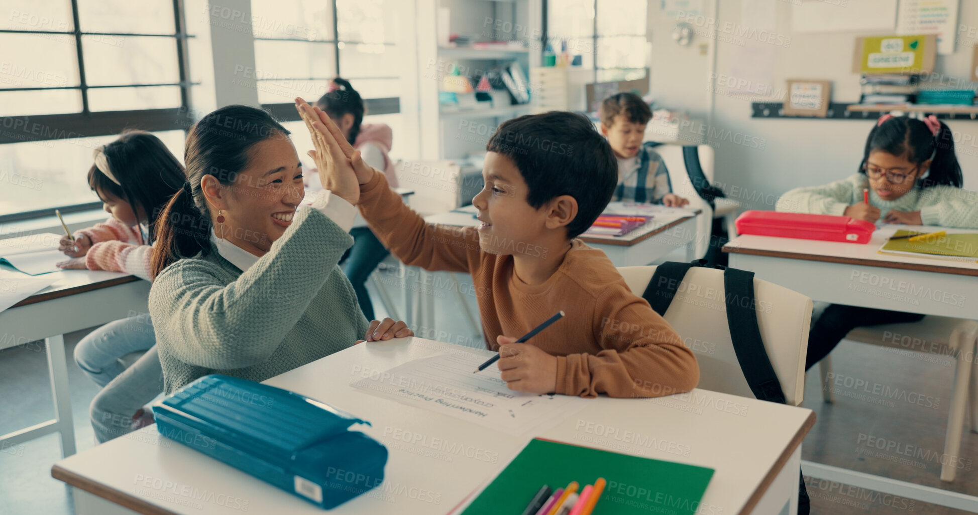 Buy stock photo Happy boy, classroom and high five with teacher for education, learning or winning at school. Young, child or kid with smile or touching hands for exam, test or success in assessment or assignment