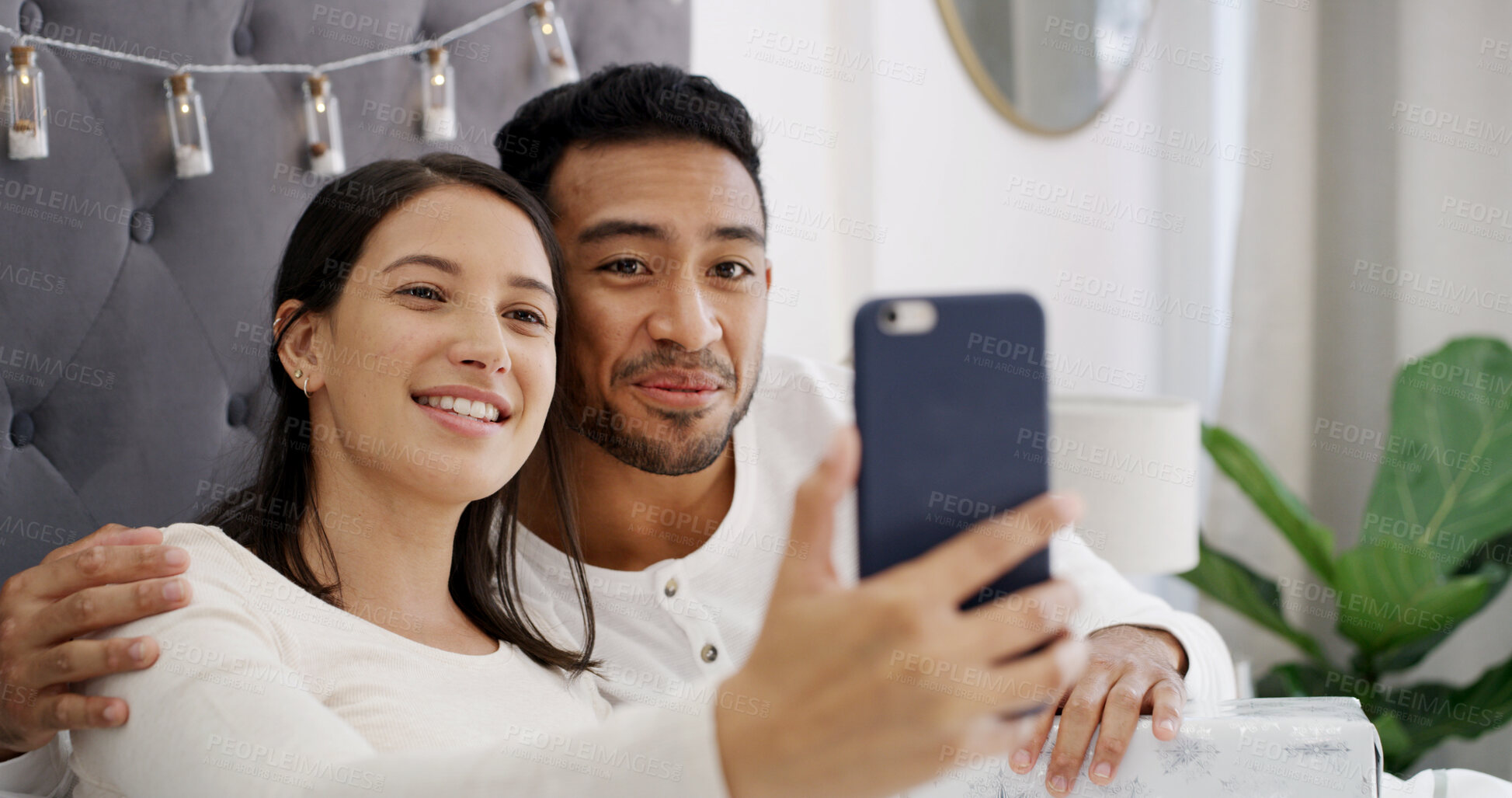 Buy stock photo Selfie, couple and celebration in bed with Christmas, profile picture and festive season for memory. Home, man and woman with present in bedroom for photography, smile and social media on holiday
