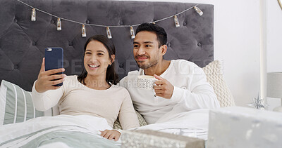 Buy stock photo Video call, couple and celebration in bedroom with Christmas, communication and coffee for festive season. Home, man and woman with present in bed for conversation, smile and social media on holiday