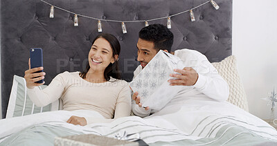 Buy stock photo Video call, couple and gift in bedroom with Christmas, communication and celebration for festive season. Home, man and woman with present in bed for conversation, smile and social media on holiday