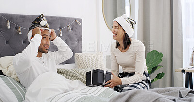 Buy stock photo Laugh, couple and celebration in bed with Christmas, present and festive season for love in home. House, man and woman with gift in bedroom for Santa hat, smile and decoration for holiday bonding