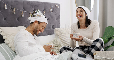 Buy stock photo Laugh, couple and coffee in bed with Christmas, present and festive season for love in home. House, man and woman with warm beverage in bedroom for Santa hat, gift and decoration for holiday bonding