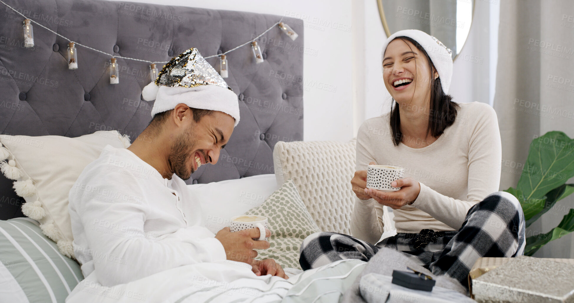 Buy stock photo Laugh, couple and coffee in bed with Christmas, present and festive season for love in home. House, man and woman with warm beverage in bedroom for Santa hat, gift and decoration for holiday bonding
