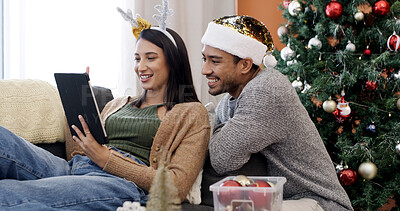 Buy stock photo Christmas, tablet and happy couple relax in home for gift shopping, search and reading online. Xmas, man and woman with tech in living room for holiday sale, ecommerce or smile for festive discount