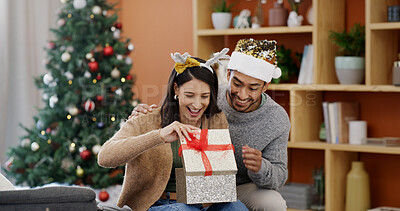 Buy stock photo Christmas, couple and smile in living room with present for holiday tradition, connection and gratitude. Happy, married people and gift in house for festive season, appreciation and bonding together.