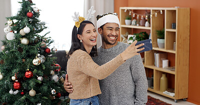 Buy stock photo Christmas, happy couple and selfie with hug in home for holiday memory, social media post or laugh. Man, woman and photo on xmas with embrace for festive celebration, capture moment and funny