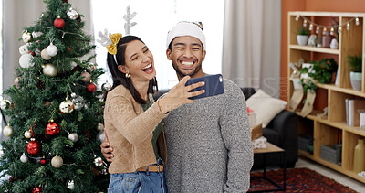 Buy stock photo Christmas, couple laugh and selfie with hug in home for holiday memory, social media post or love. Man, woman and profile picture on xmas with embrace for festive celebration, smile and funny partner