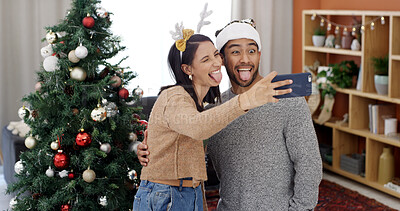 Buy stock photo Christmas, funny face and selfie of couple with hug for holiday memory, social media and comic post. Man, woman and photo on xmas with embrace in home for festive celebration, goofy and tongue out