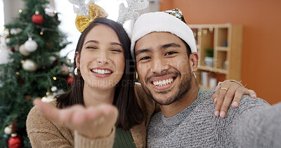 Buy stock photo Blow kiss, christmas and video call pov with couple in living room of home together for season greeting. Hug, portrait and smile of with happy people in streaming for festive celebration or tradition