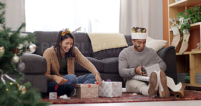 Buy stock photo Christmas, home and couple with gift, wrapping paper and bonding together with happiness. Xmas, relationship and man with woman, excited and celebration with tradition, present and festive season