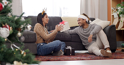 Buy stock photo Christmas, home and couple with surprise, present and bonding together with happiness, wow and omg. Xmas, love or man with woman, shocked and celebration with tradition, gift and festive season
