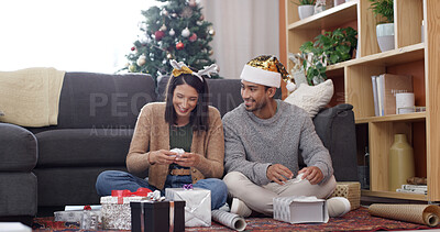 Buy stock photo Christmas, wrapping paper and couple with gift, excited and bonding together with surprise. Xmas, love or man with woman, festive season and celebrate with tradition, present or home with decoration