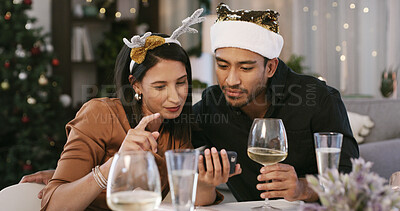 Buy stock photo Christmas, wine or couple with phone in home, check social media or reading celebration message. Festive tradition, alcohol or people with mobile for season greeting, holiday wishes or online chat