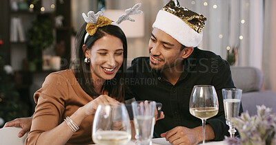 Buy stock photo Happy, couple and present for woman, Christmas or people with smile for romantic dinner with alcohol. Giving, gift and man with love for partner, festive season and wine for Xmas celebration in house