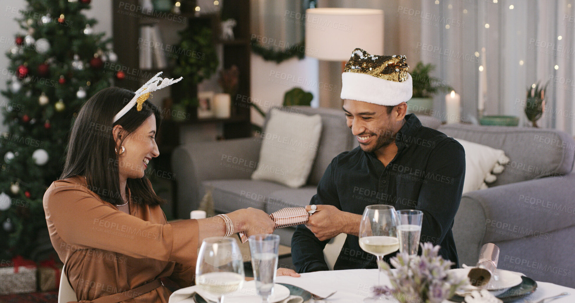Buy stock photo Happy, couple and Christmas cracker in home, romance and excited for present, alcohol or celebration. Laughing, man and woman on festive season, love and fun on December holiday and bonding in house