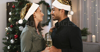 Buy stock photo Christmas, happy couple or love in house with champagne for holiday tradition, care or bonding together. Married people, alcohol and smile in living room with festive season, connection and xmas hat.