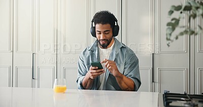 Buy stock photo Man, relax and headphones with phone at house for social media, listening to music and subscription. Male person, orange juice and mobile for streaming podcast, download playlist and entertainment