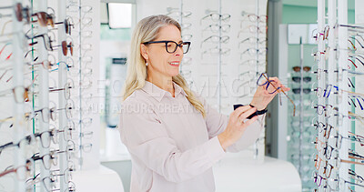 Buy stock photo Vision, woman and cleaning glasses in store, eye care and maintenance of stock with smile. Shop, eyewear and mature person with cloth fabric for frame, optometrist and check spectacles for health