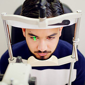 Man, eye test and above with machine for optometry inspection, laser ...
