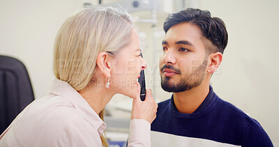Buy stock photo Optometrist, man and appointment with light, tools and clear vision exam with consultation. Medical service, ophthalmologist and person with eye care, ophthalmoscope or lens test with healthcare