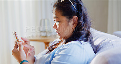 Buy stock photo Reading, woman and scroll with phone on couch, blog update notification and clear email inbox on weekend. Connectivity, check social media and mature person with mobile in home, ebook app and relax